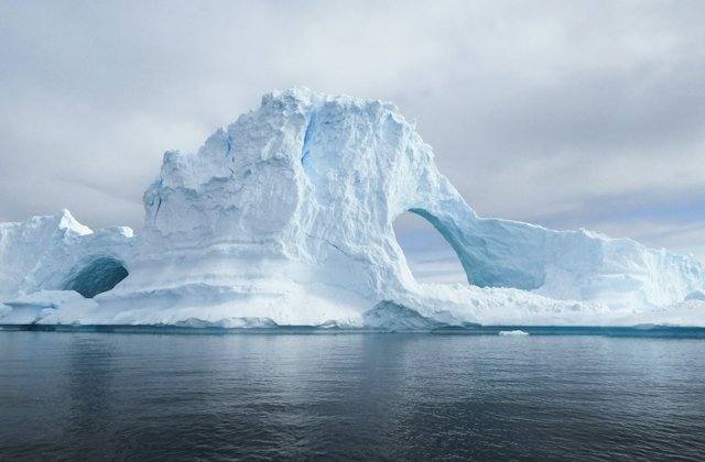 Blue iceberg with a natural arch