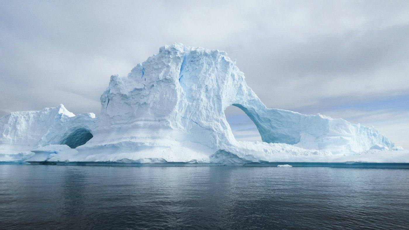 Blue iceberg with a natural arch