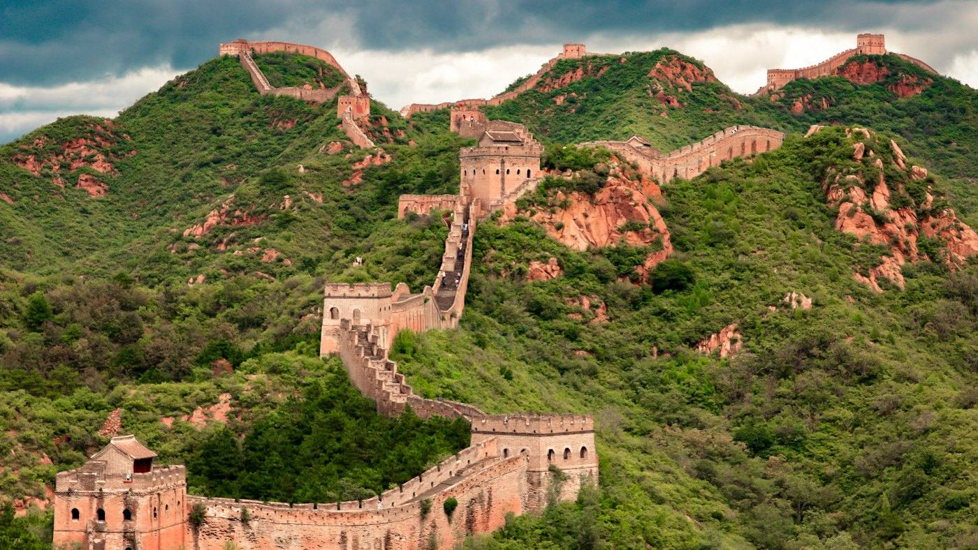The Great Wall winding over green mountains